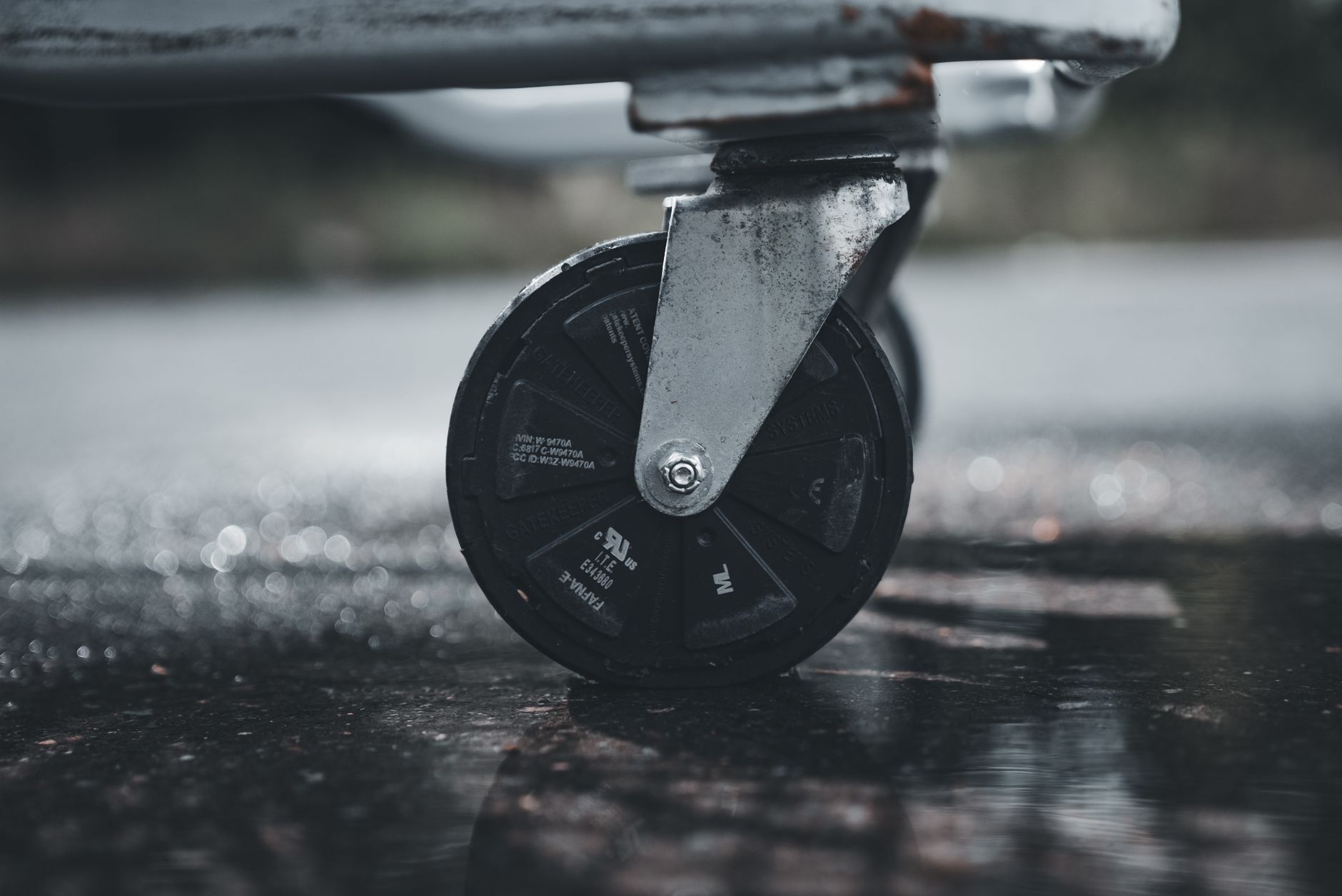 Close view of rubber casters on a rolling cart standing on a hardwood floor