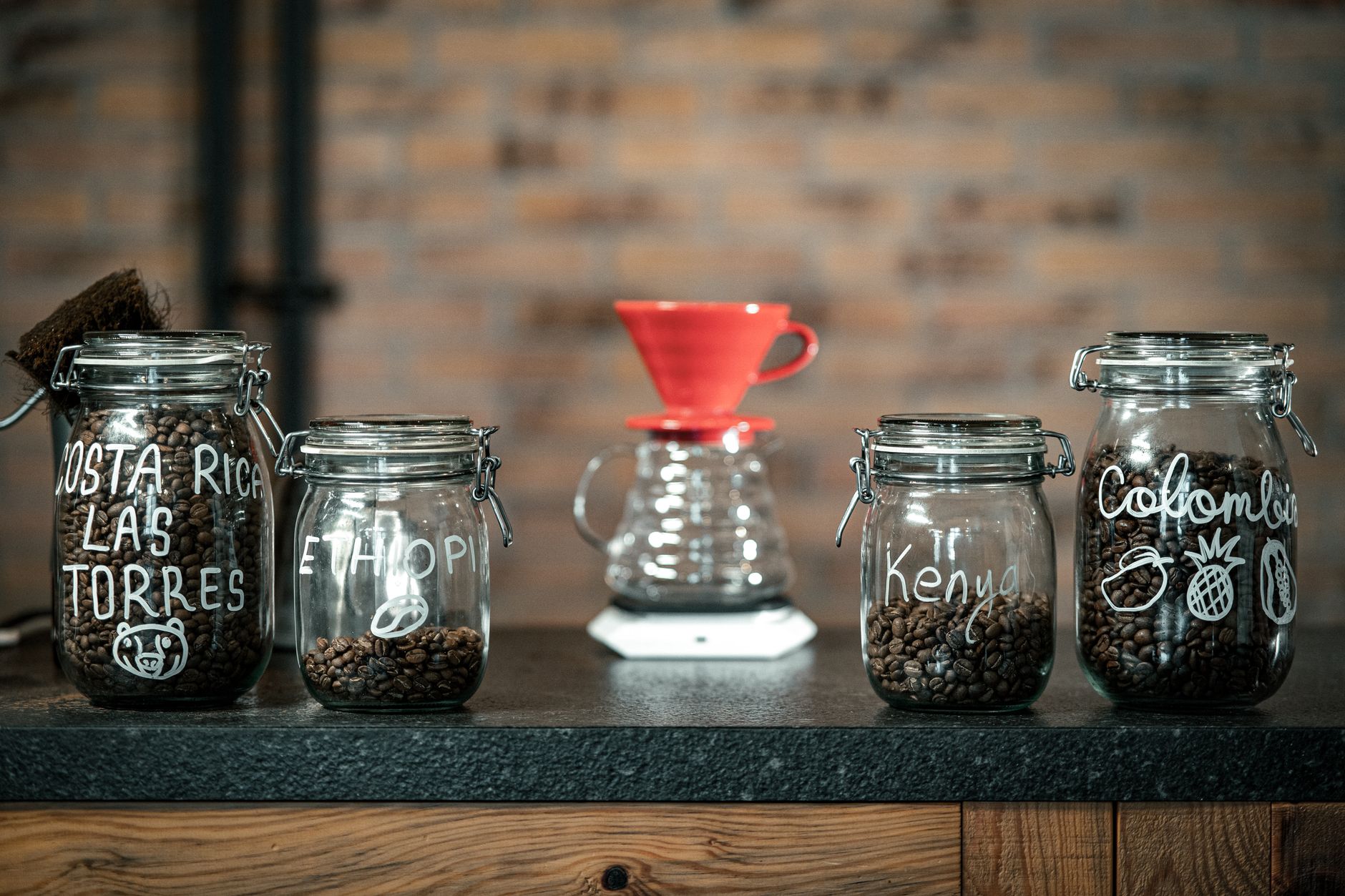 Coffee beans and sugar decanted into matching glass canisters on a counter