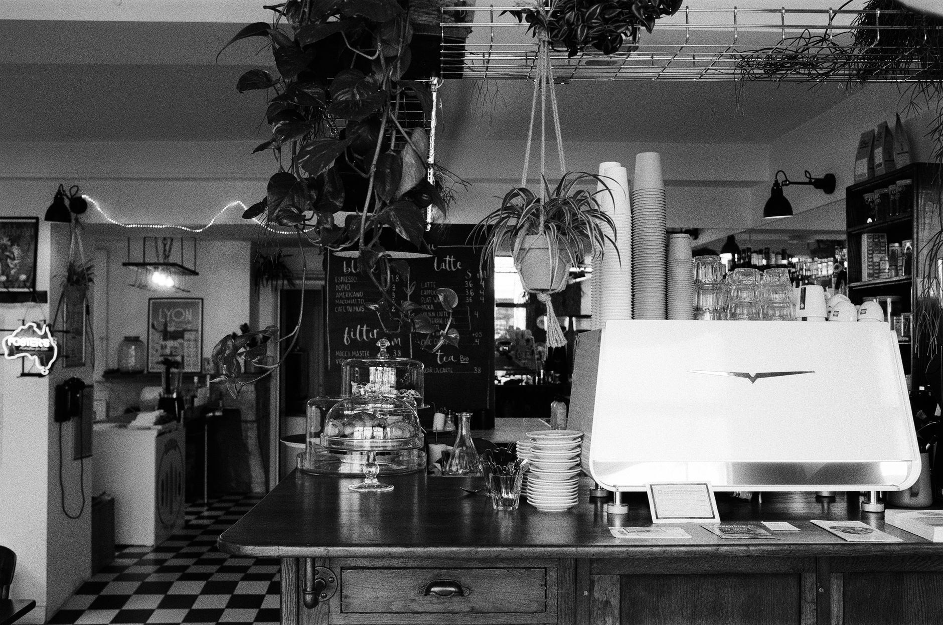 A restrained coffee station with a single small plant and one framed print behind it