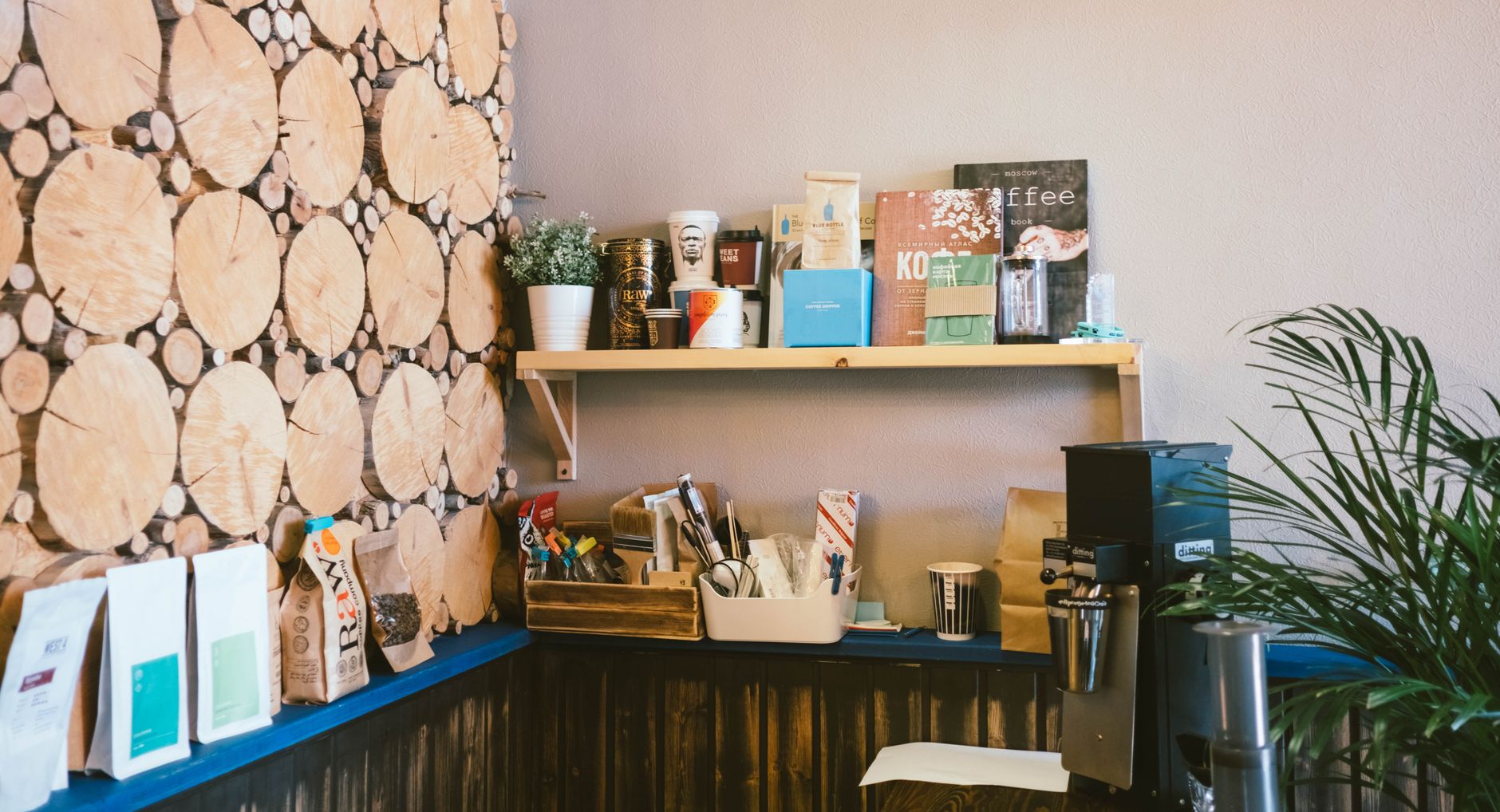 A triangular wooden corner shelf unit holding mugs and a coffee canister