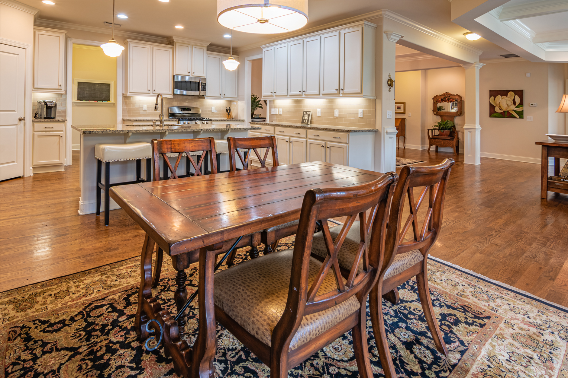 A counter-height wooden table standing flush against the end of a kitchen island