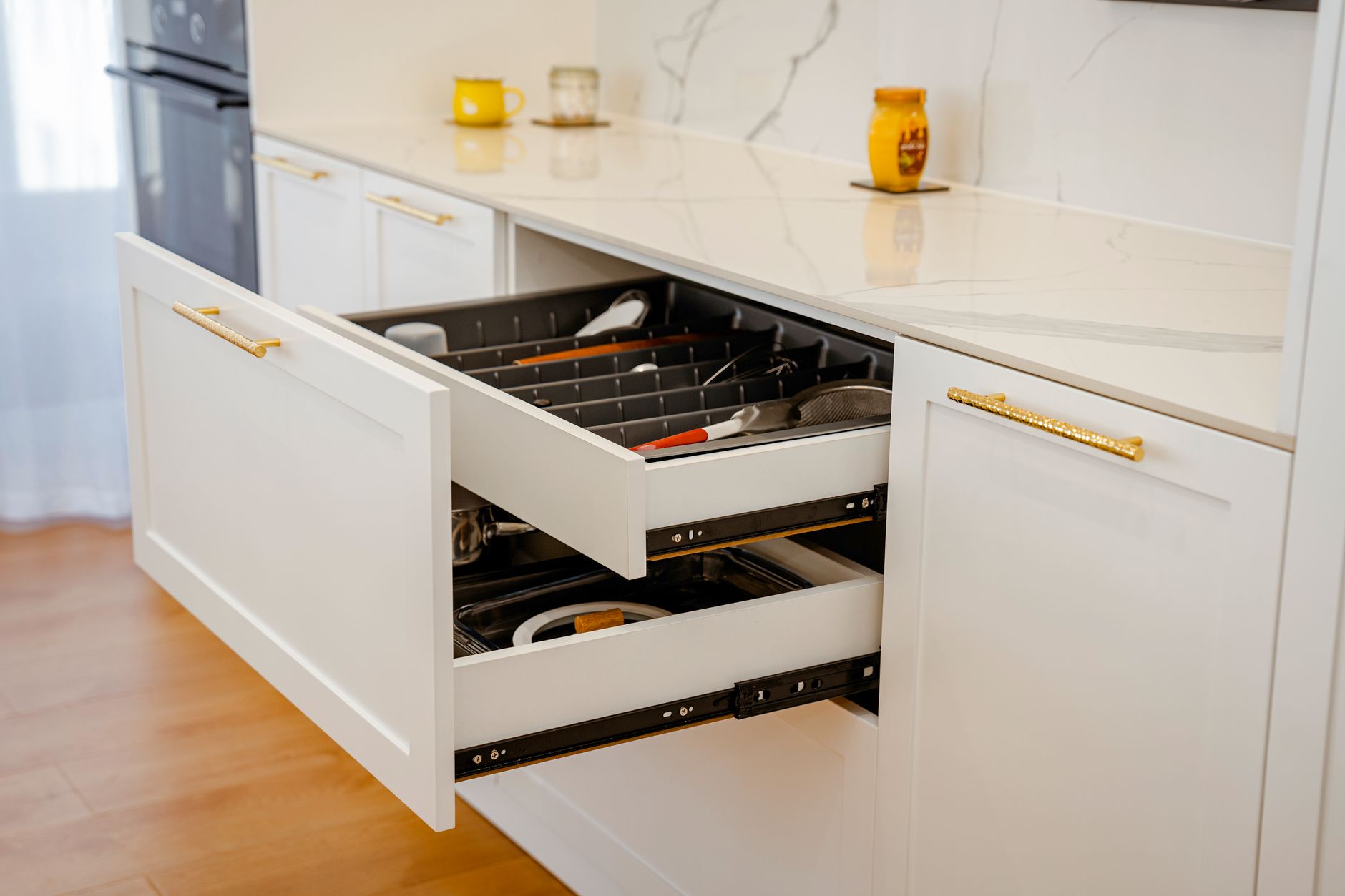 An open kitchen drawer with coffee pods arranged in rows inside a shallow insert