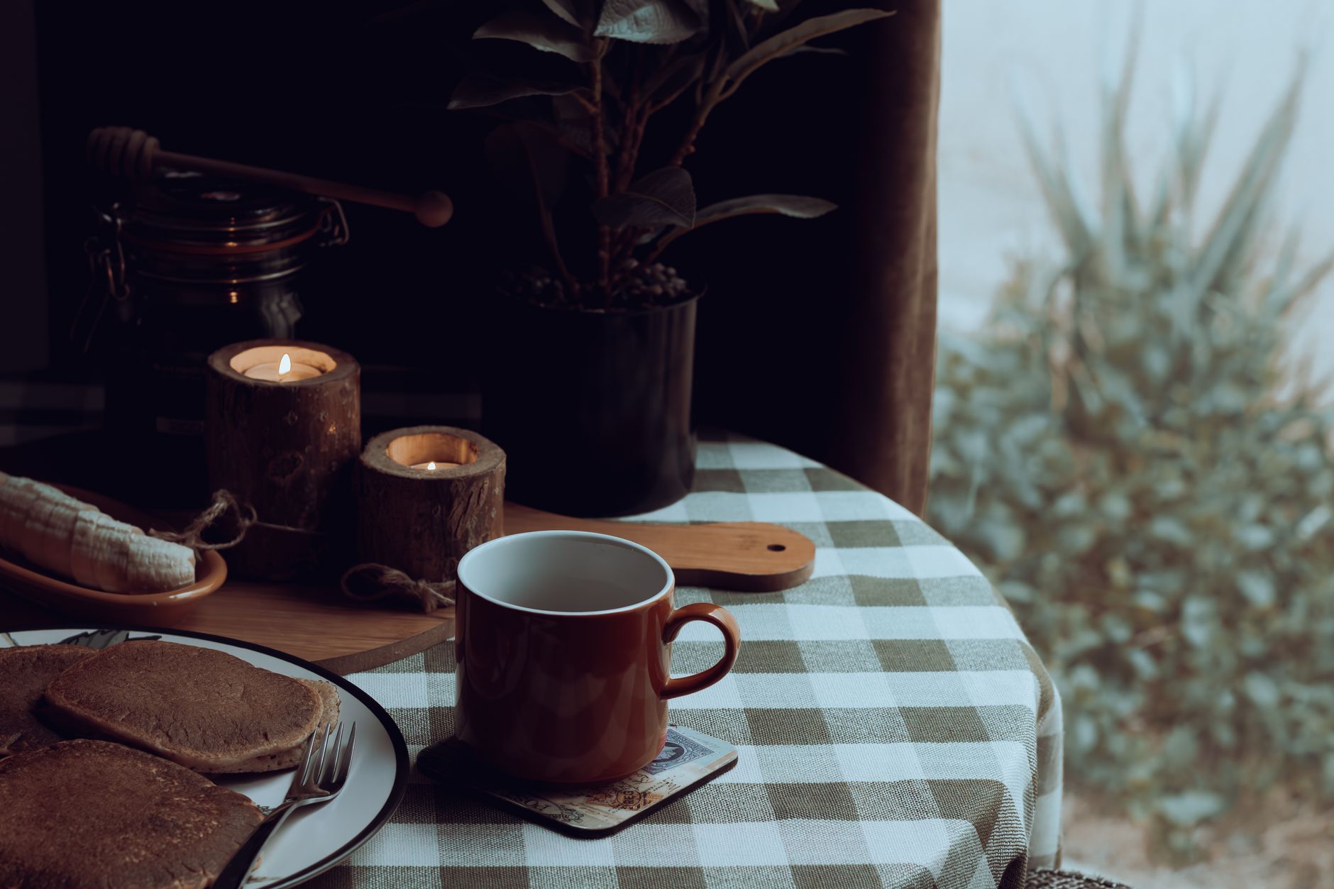 Ceramic mugs stacked two deep on a wooden serving tray next to a linen towel