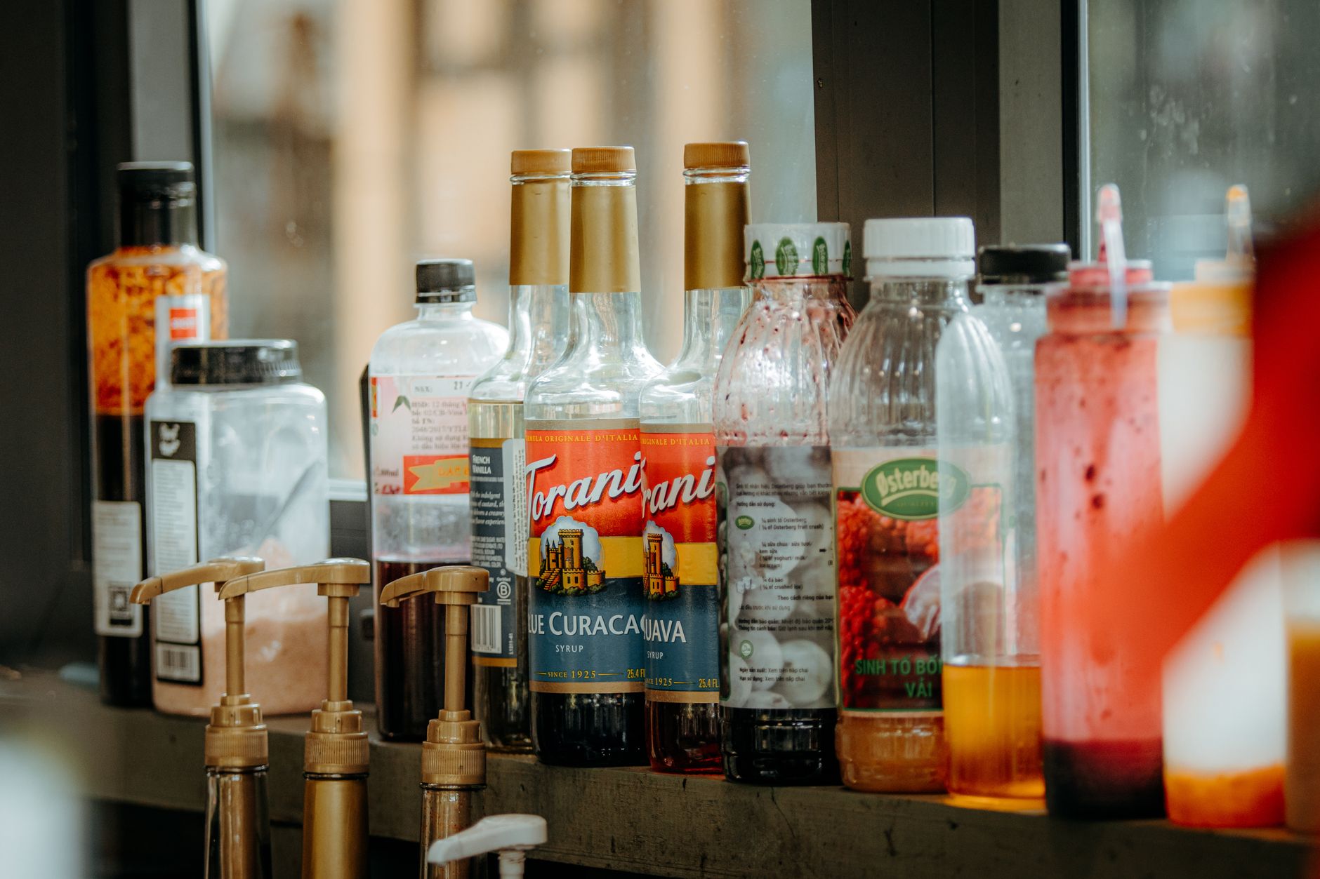 Pump syrup bottles grouped on a round turntable next to an espresso machine